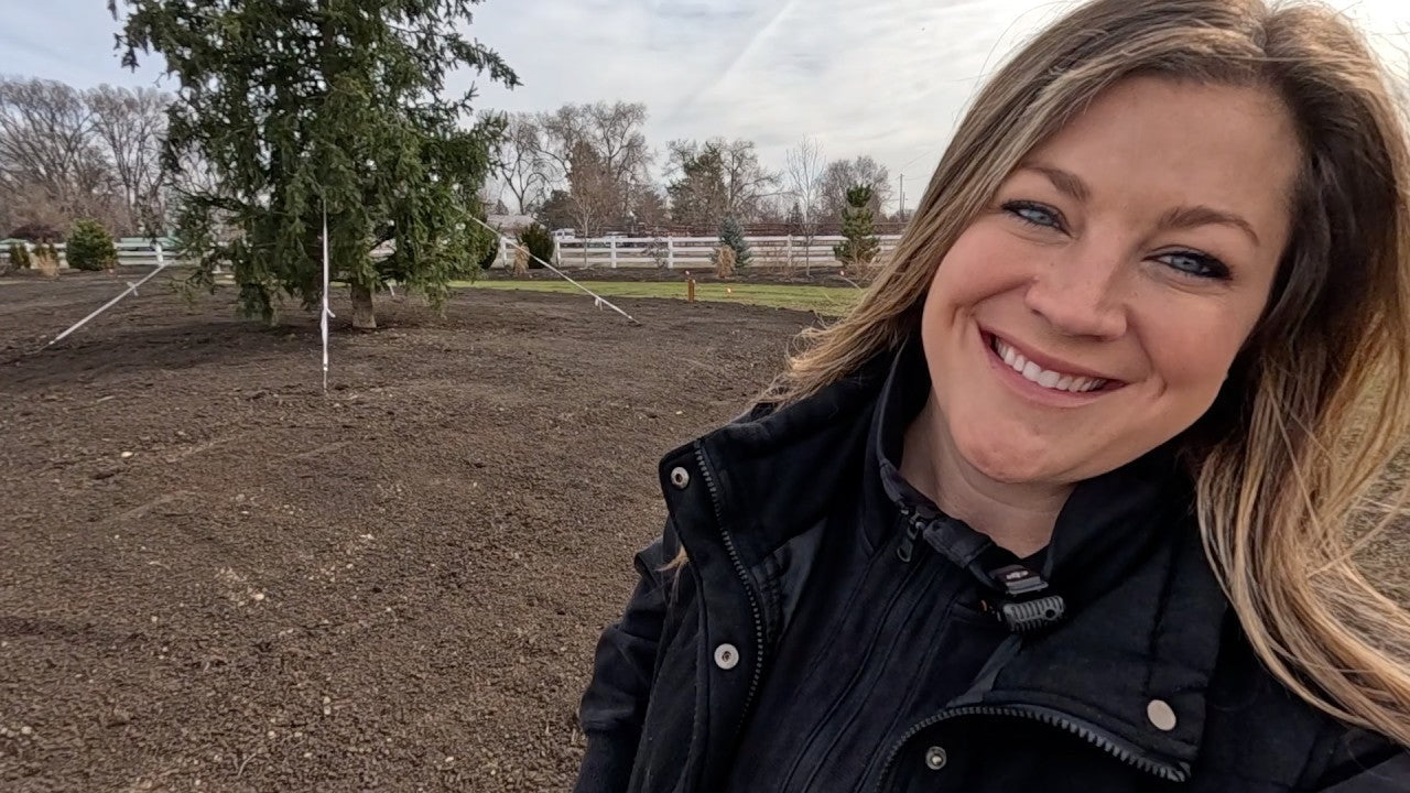 Laura smiling in her yard ready to plant seeds