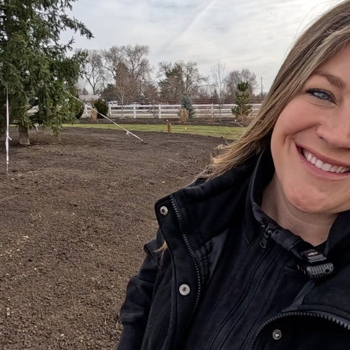 Laura smiling in her yard ready to plant seeds