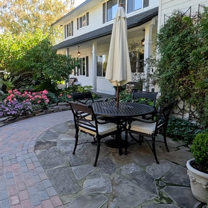 Garden with chairs and umbrella and plenty of flowers