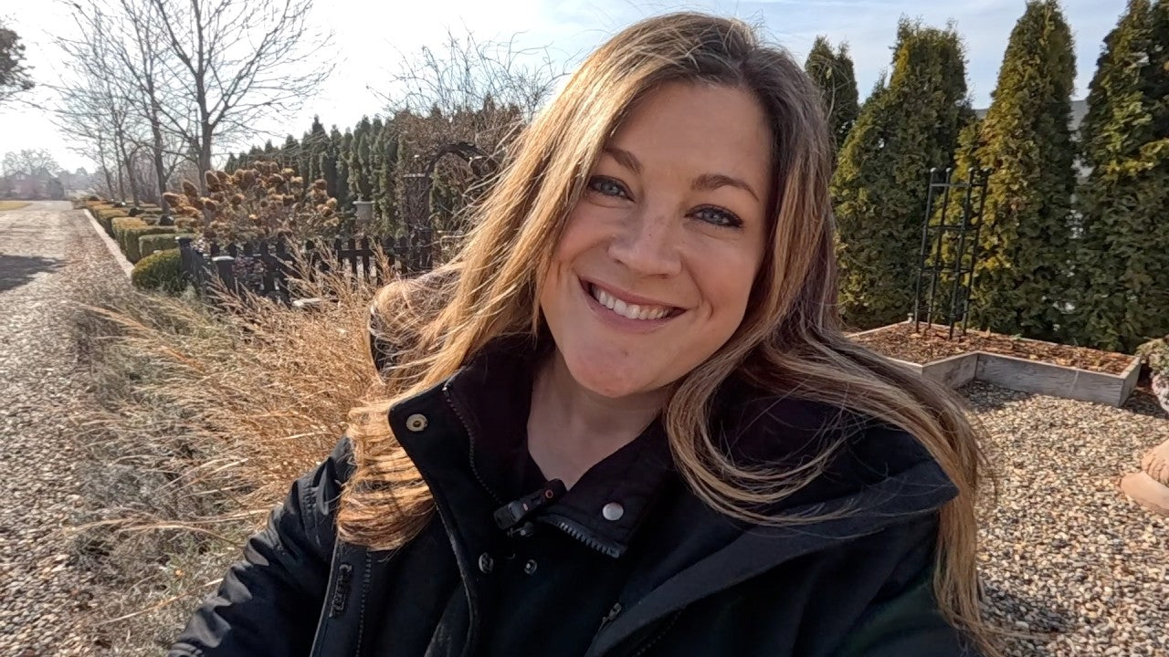 laura smiling behind trees and wintery plants