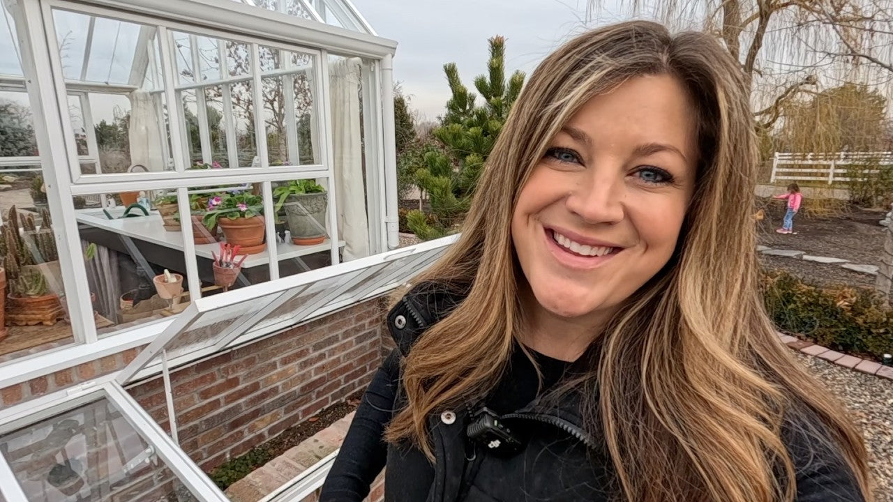 laura smiling next to the window of her green garden