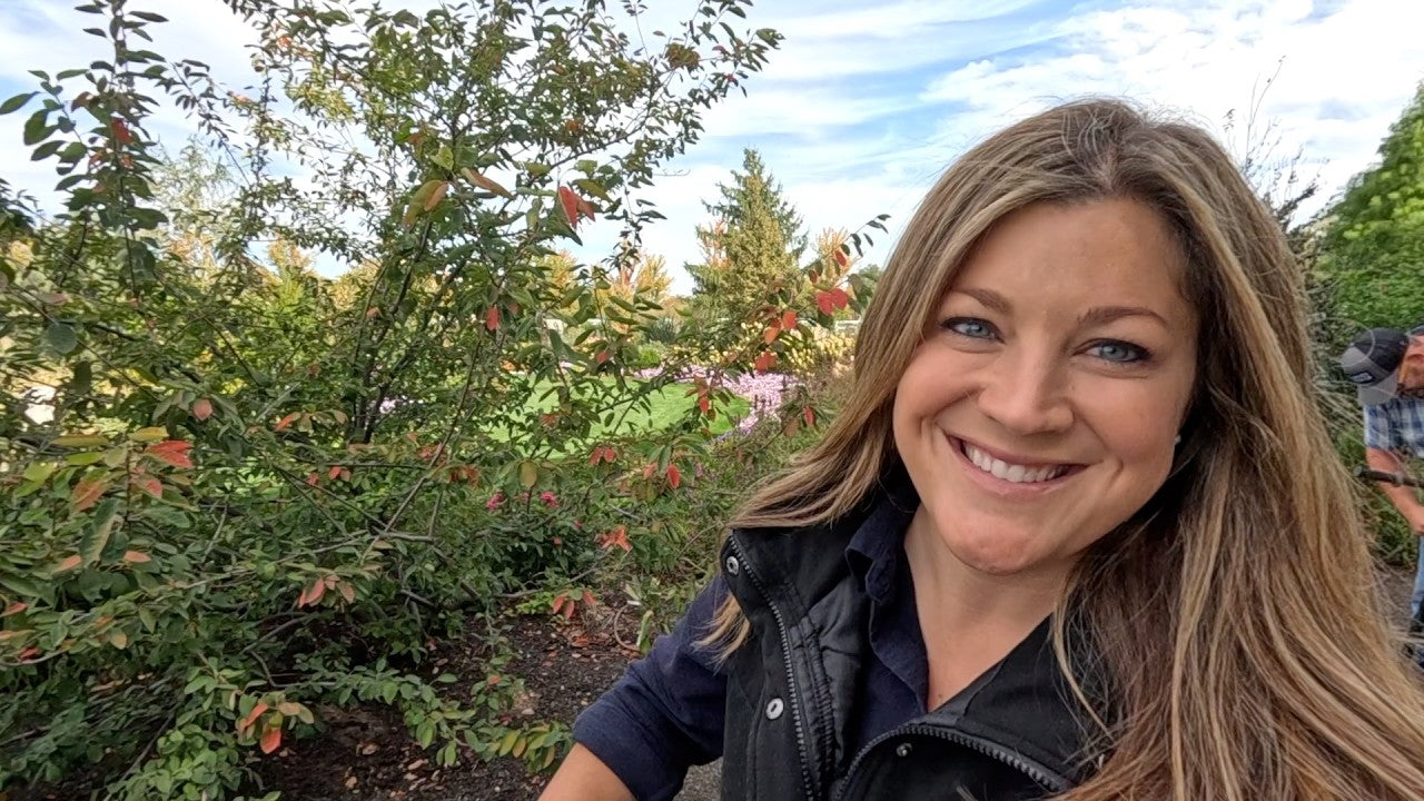 Laura smiling next to a plant