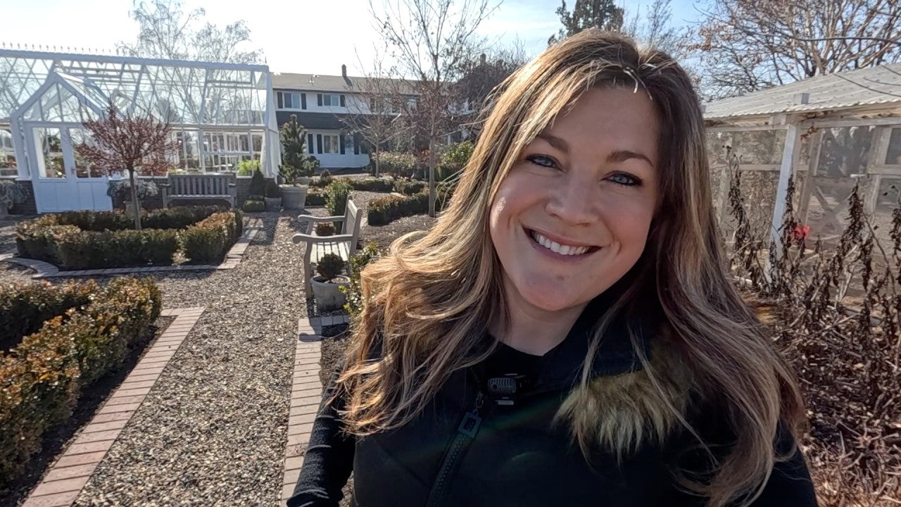 laura smiling behind her yard and garden house