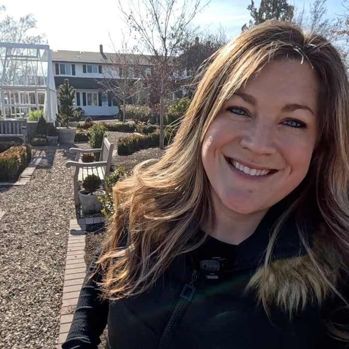 laura smiling behind her yard and garden house