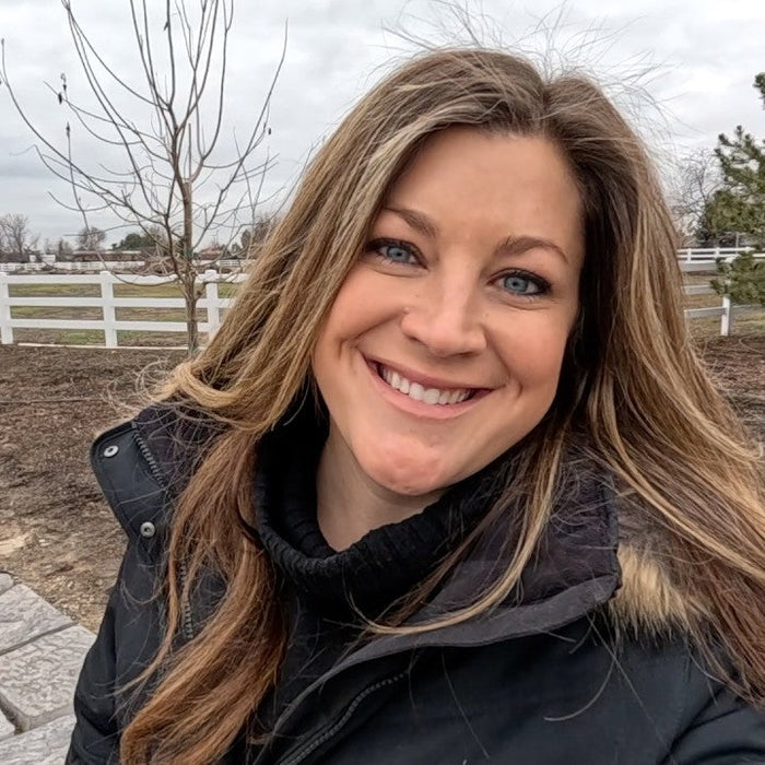 Laura smiling behind an entryway in winter