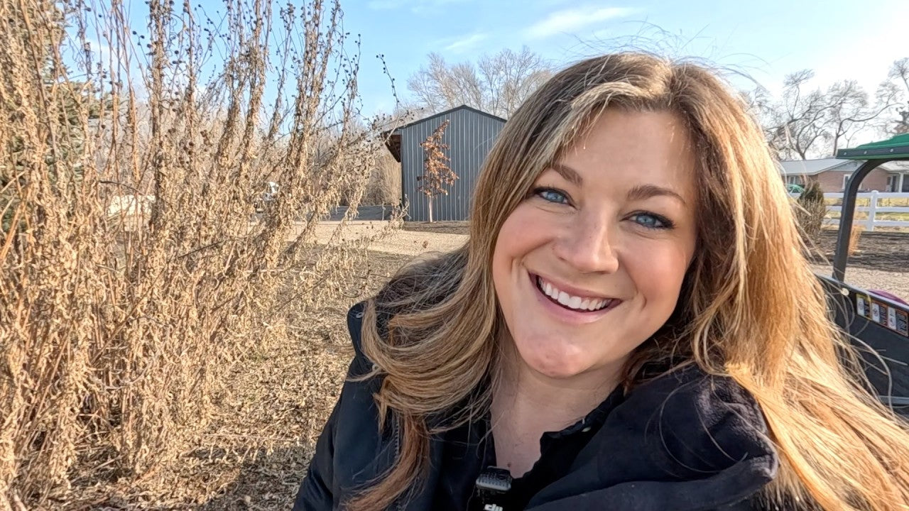 Laura smiling behind a wintery plant