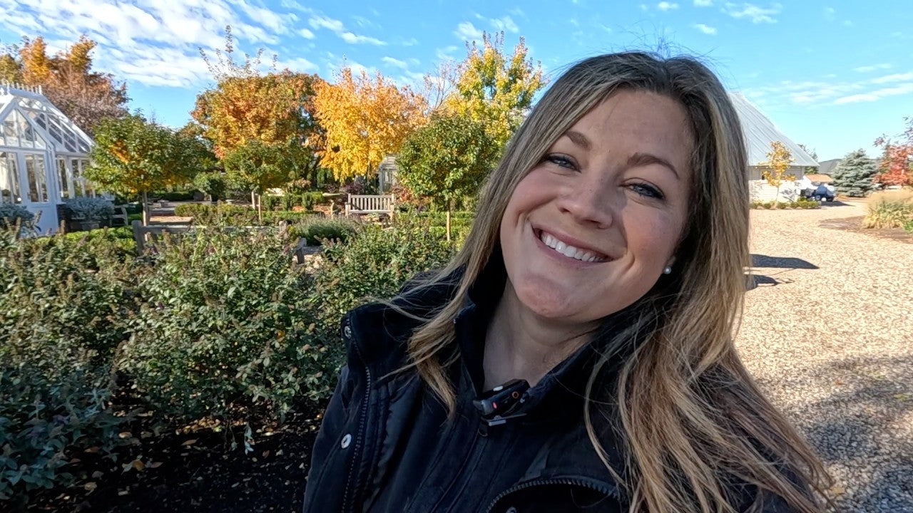 Laura smiling with a house and trees as the background