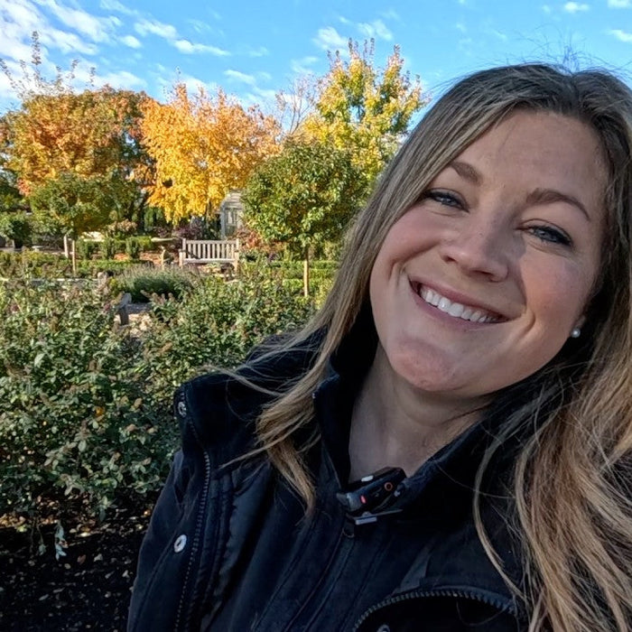 Laura smiling with a house and trees as the background
