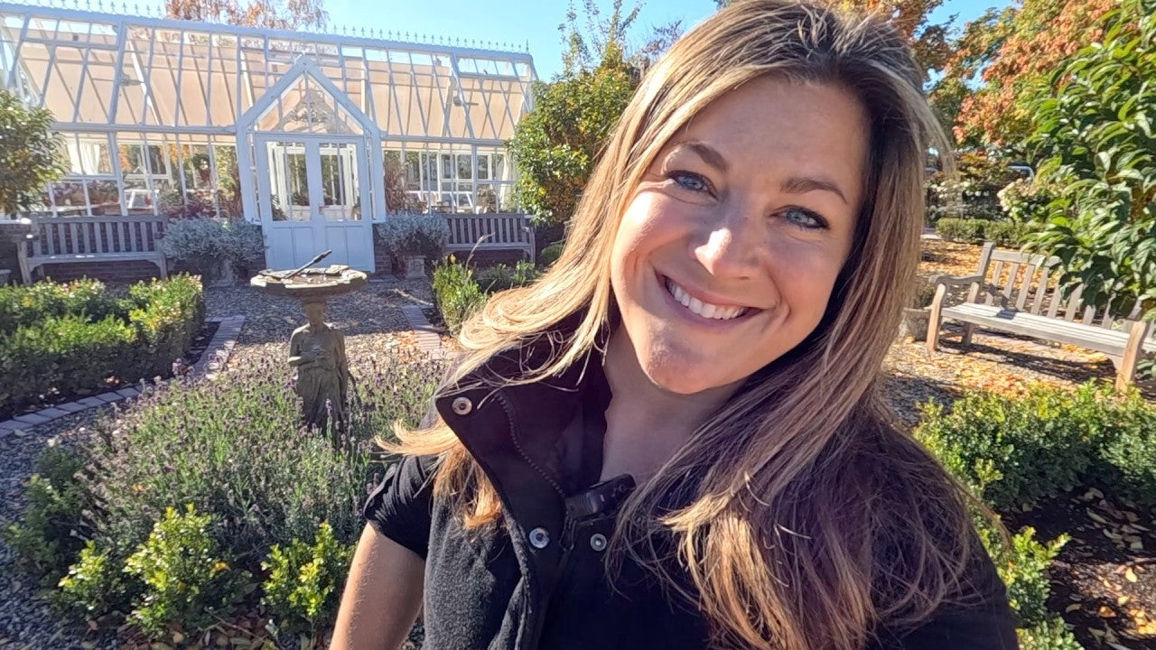 laura smiling in front of her garden green house