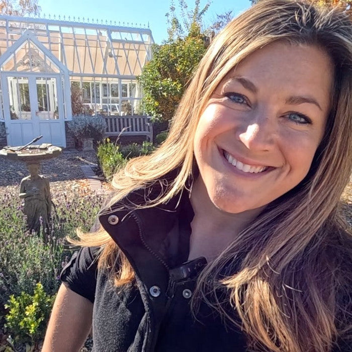 laura smiling in front of her garden green house