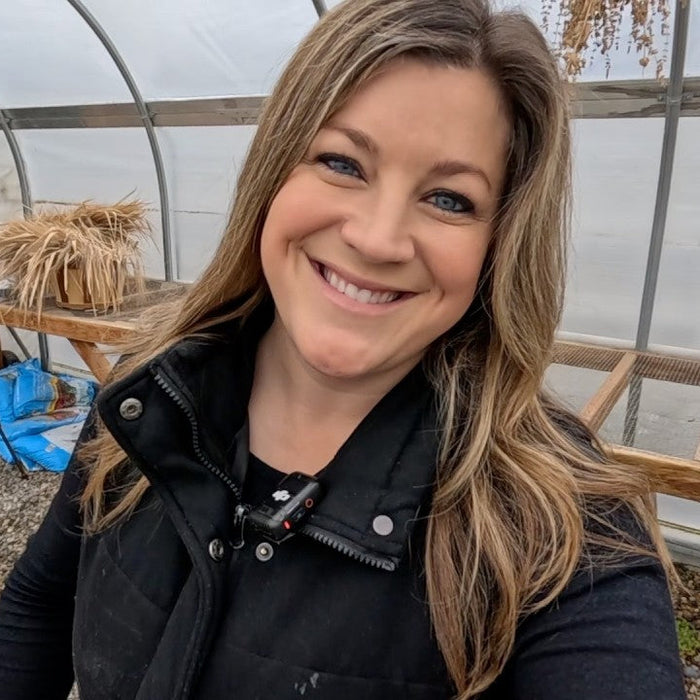Laura smiling with some wood tools in the back
