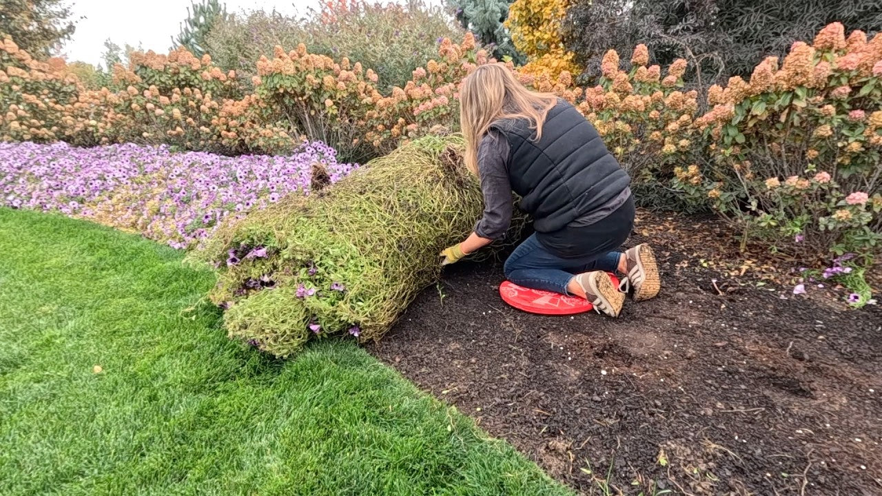 Laura planting in a garden on her knees