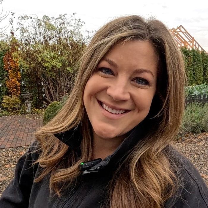 Laura smiling behind the garden