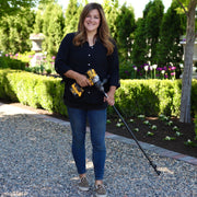 Woman holding a power tool in a garden setting