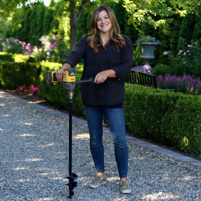 Laura holding a gardening tool in a garden setting
