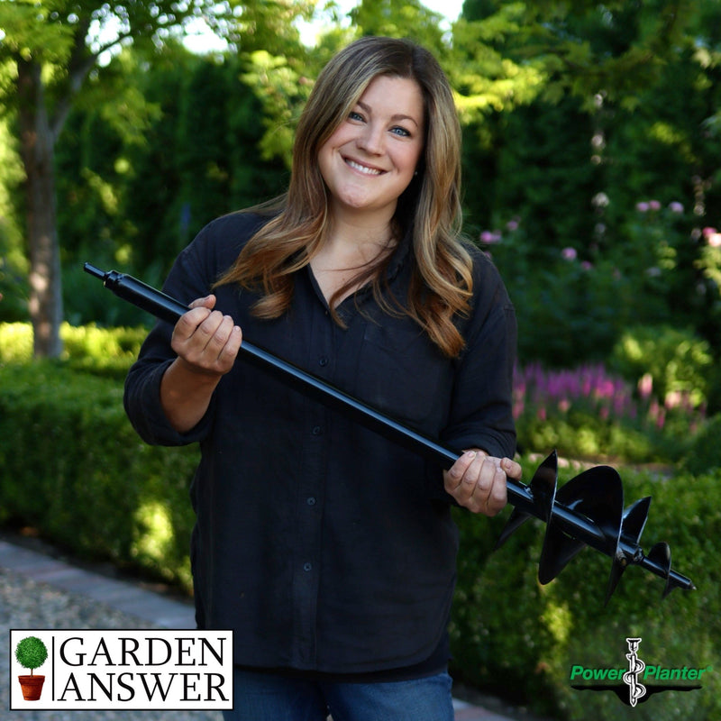 Woman holding a garden auger with 'Garden Answer' and 'Power Planter' logos in a garden setting.