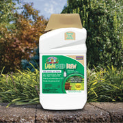 Container of lawn weed brew on a stone surface with garden background