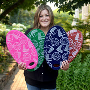 Laura holding four small kneeling pads with Garden Answer design in pink, green, red, and blue colors.