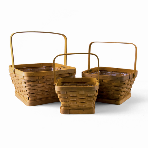 The Adorable Harvest Basket Set includes three square woven wooden baskets in graduating sizes—perfect for use as garden or harvest baskets—each designed with a sturdy handle and a clear plastic liner, all displayed on a plain white background.