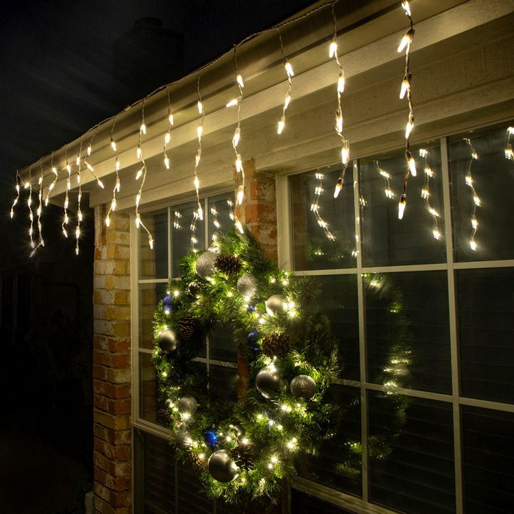 warm white icicle lights tucked into base of garland for window display